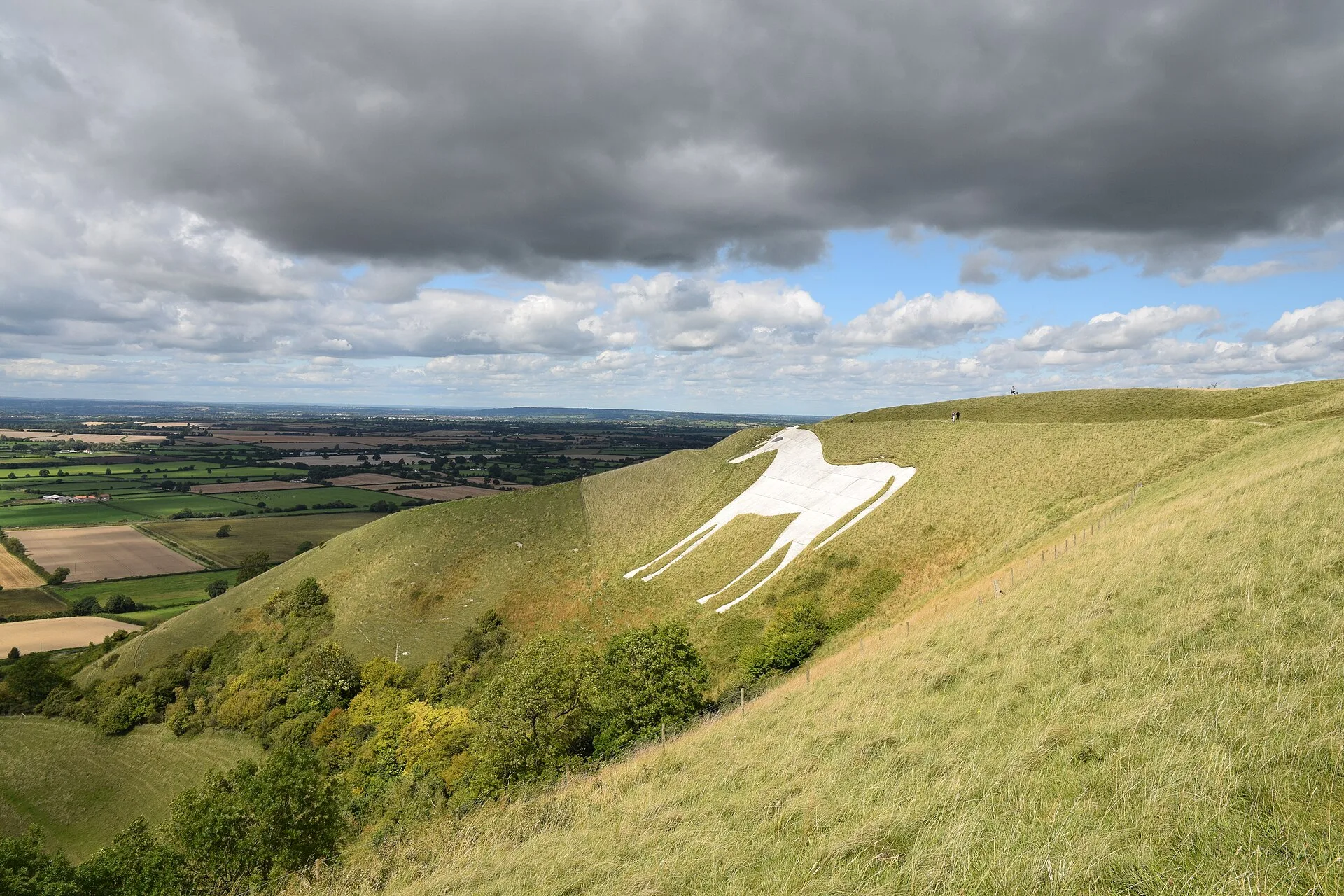 The Westbury White Horse cut into the green hillside below Bratton Camp